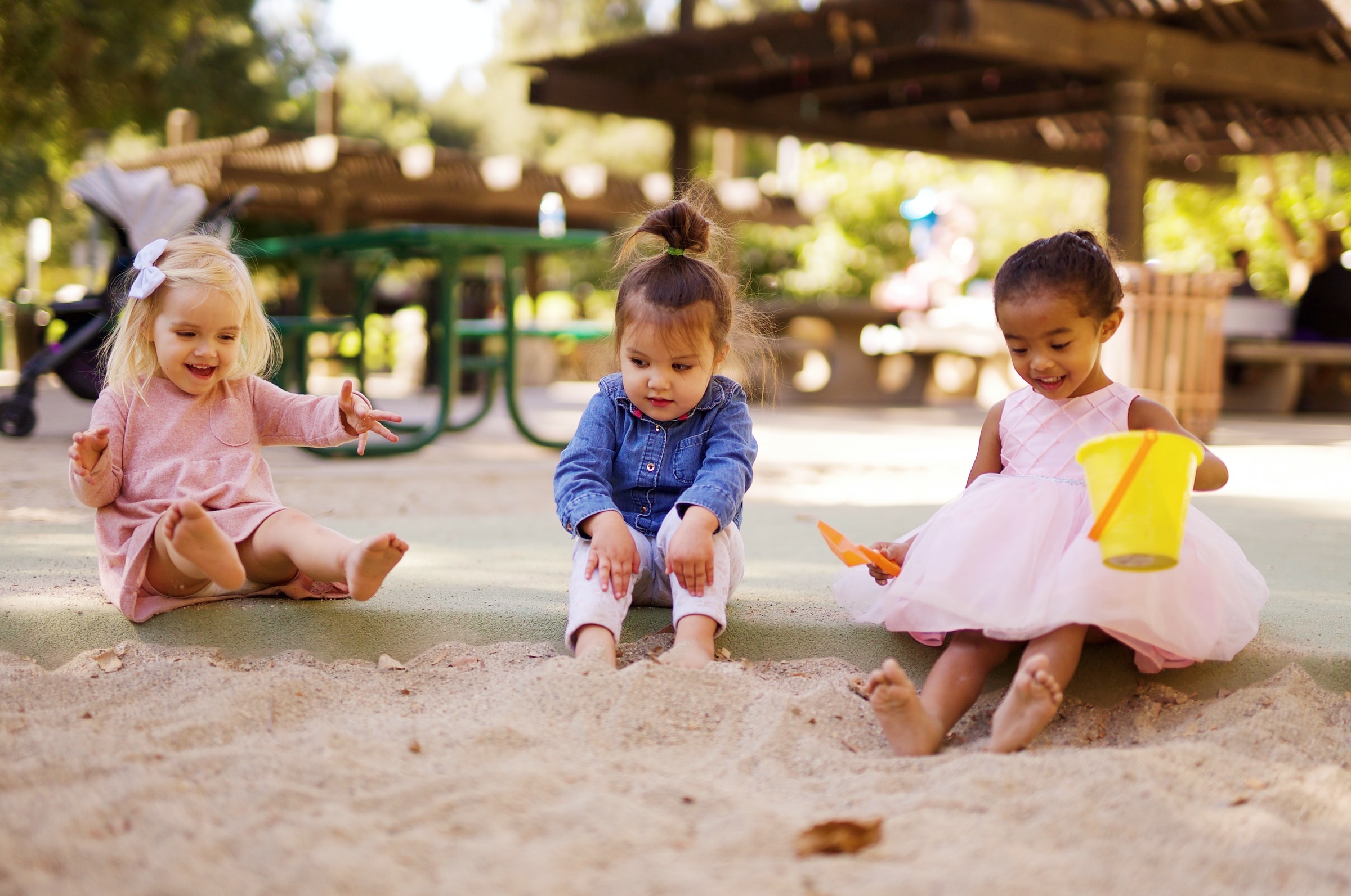 three kids playing in the sandbox