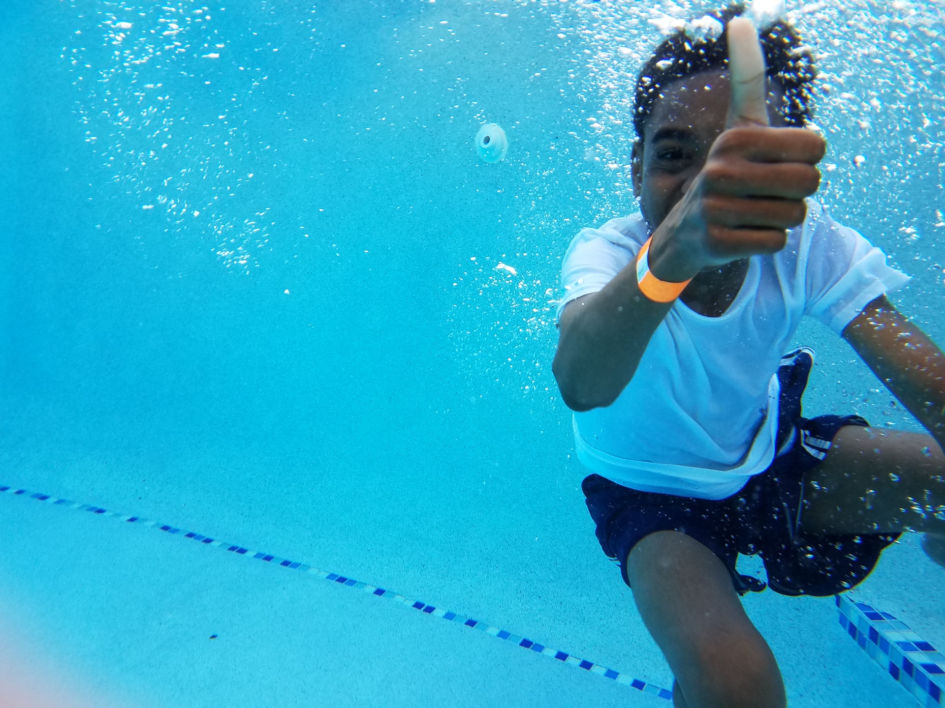 boy showing thumbs up under the water