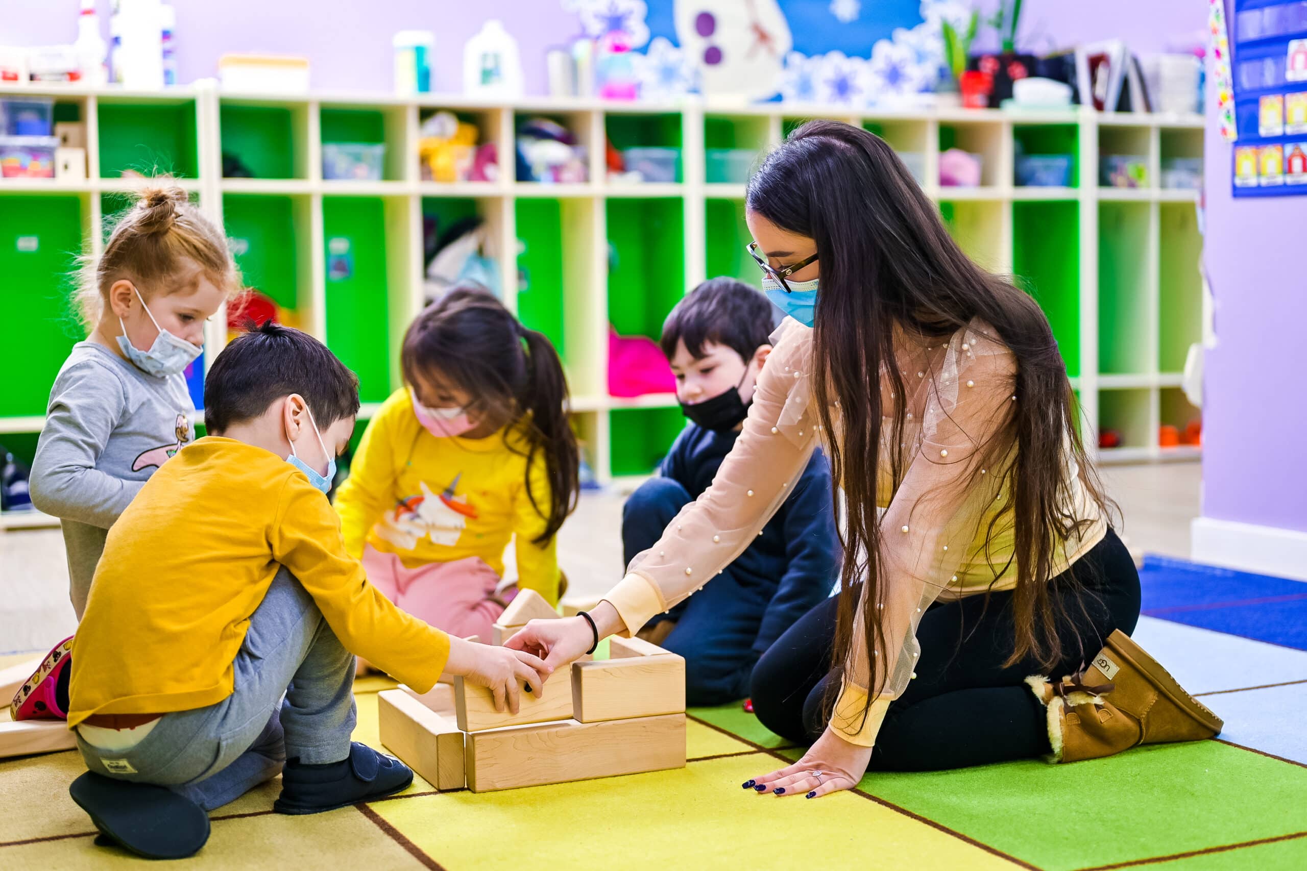 group of children playing the bricks with a teacher