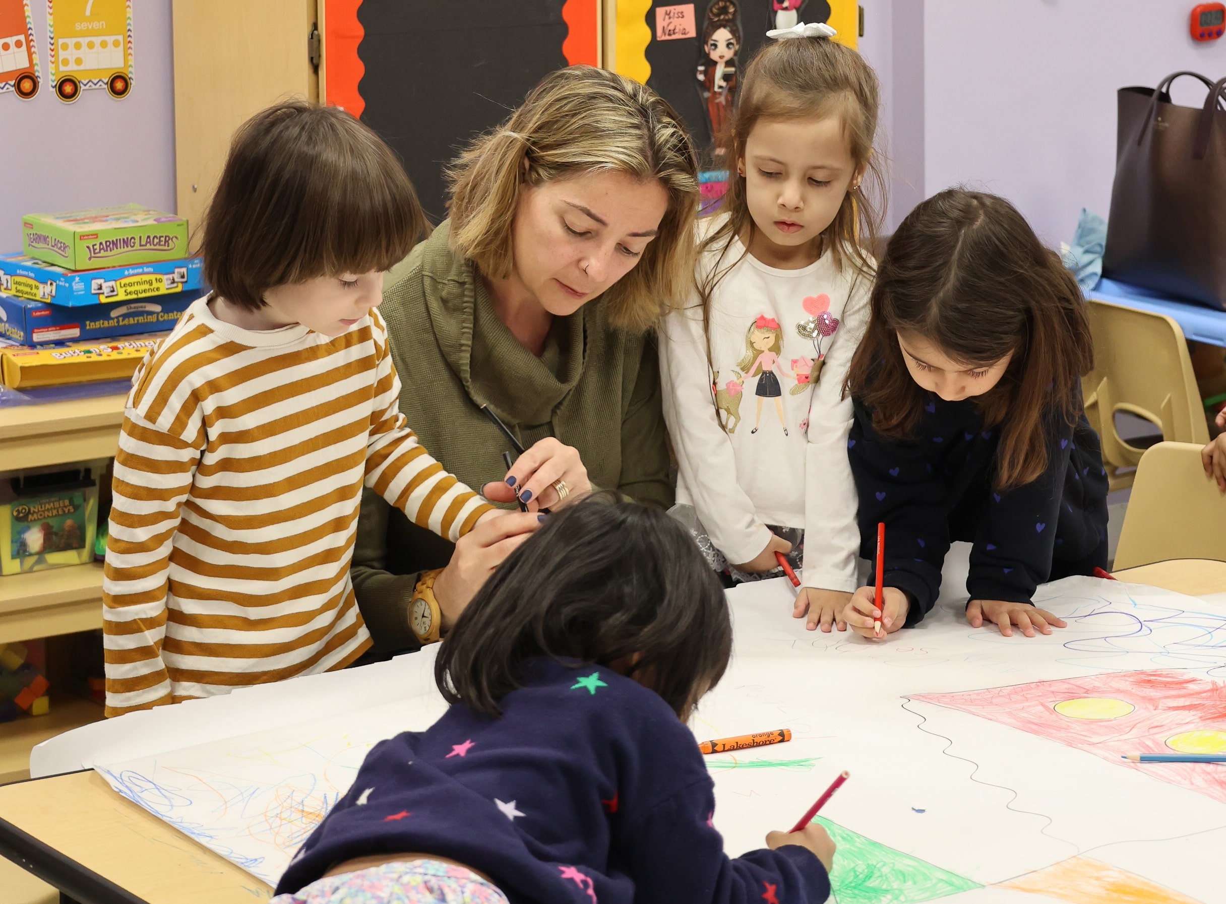 Teacher guiding children in an art class at Little Scholars Daycare.