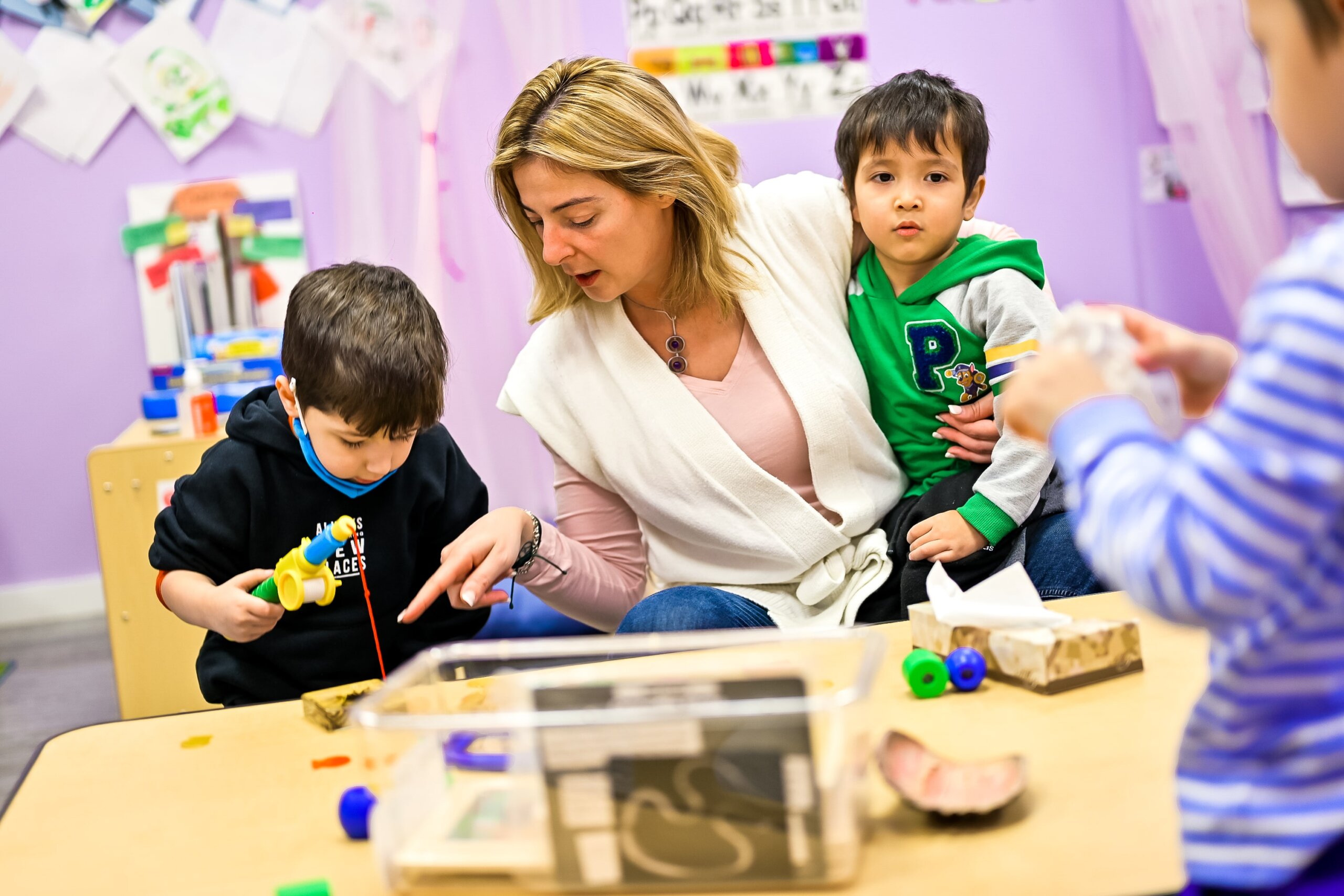 A teacher at Little Scholars Daycare attentively engaging with children during a learning activity.