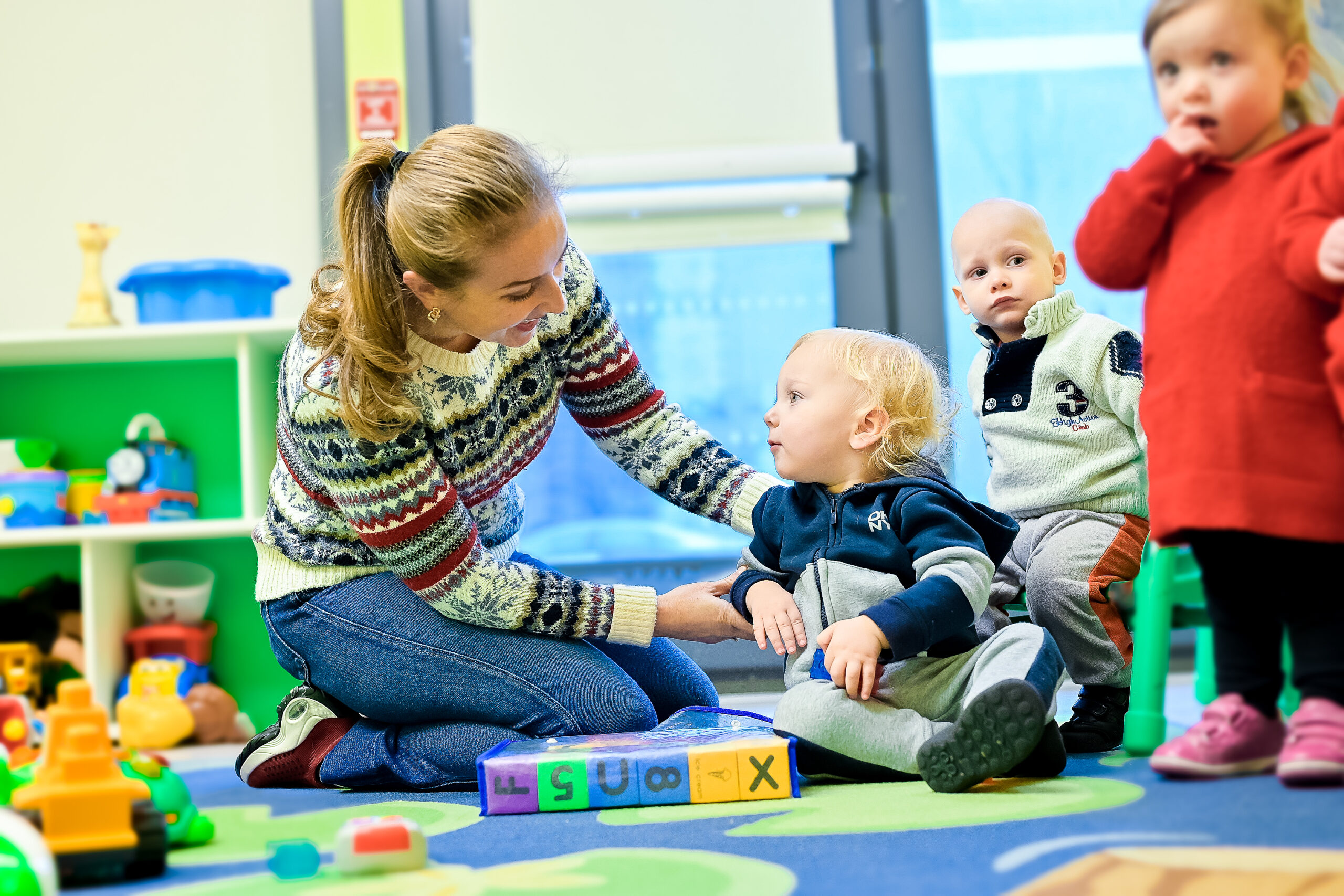 Teacher with blond hair, smiling. Next to him is a child in Little Scholars Daycare