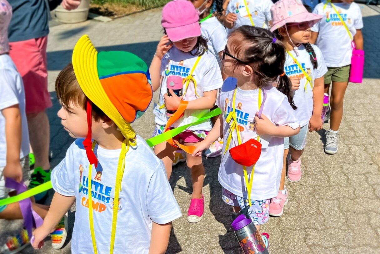 Eager children from Little Scholars Daycare walking together on a sunny day during an educational field trip