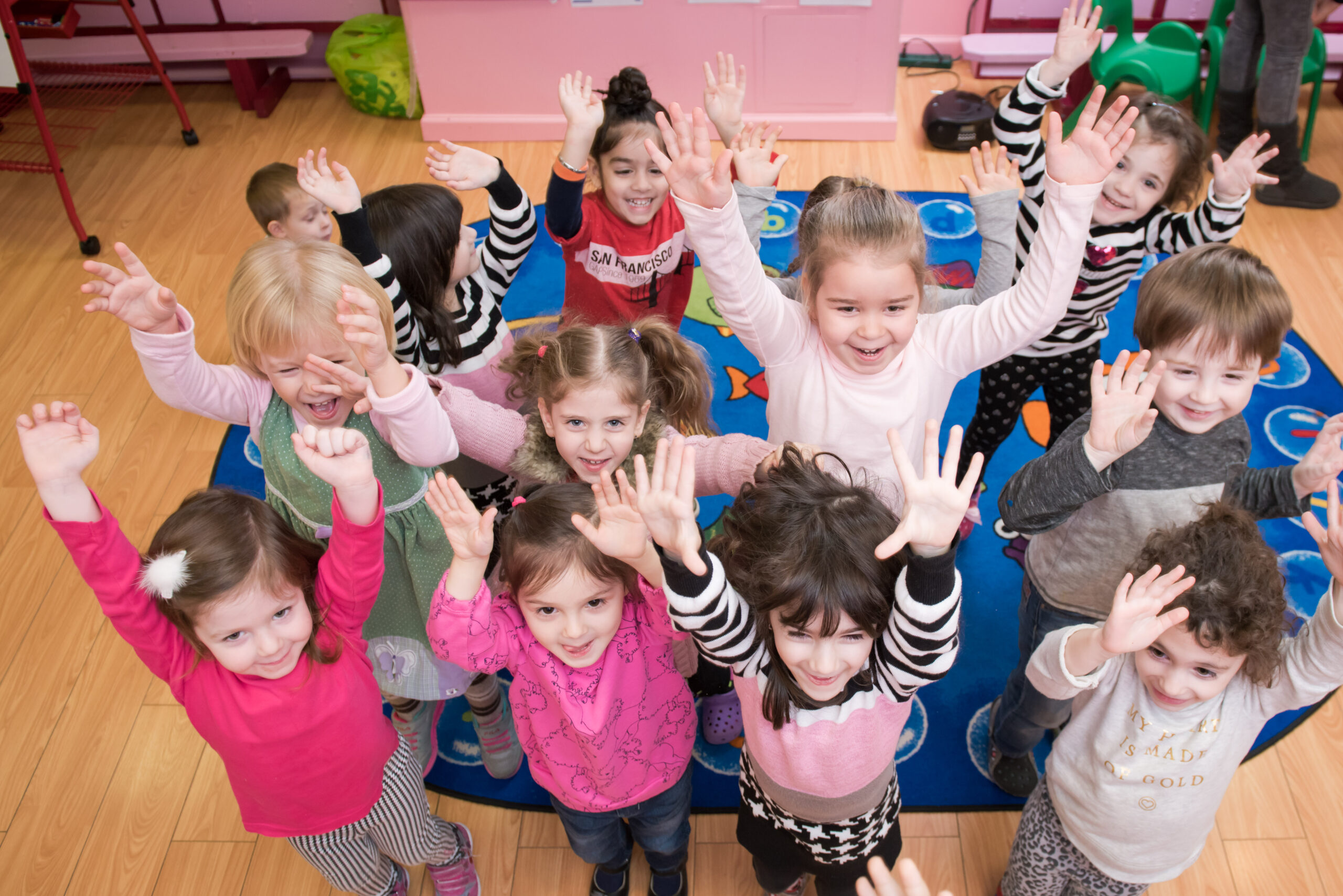 Children with their hands up in the Daycare Little Scholars Brooklyn NY