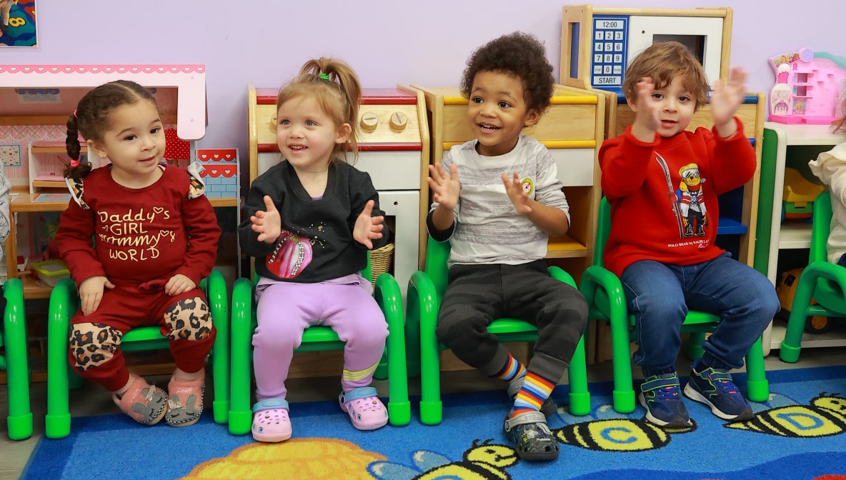 Group of preschoolers clapping hands during an activity at Little Scholars Daycare