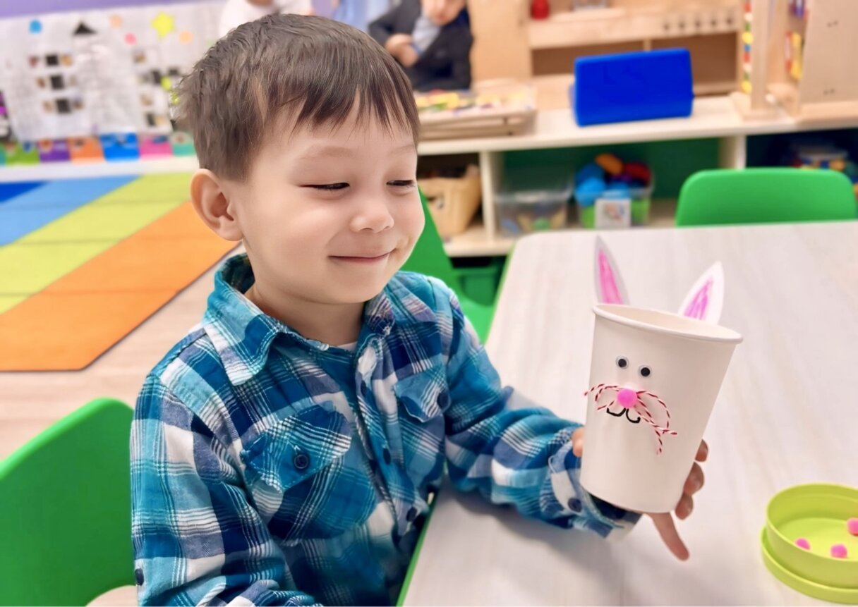 Happy boy holding an eco-friendly Easter bunny cup he crafted, an activity combining fun with sustainability