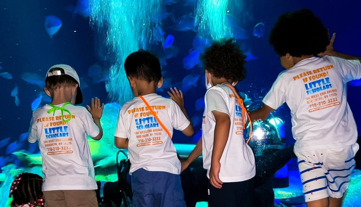 Children fascinated by marine life at an aquarium for a spring educational activity