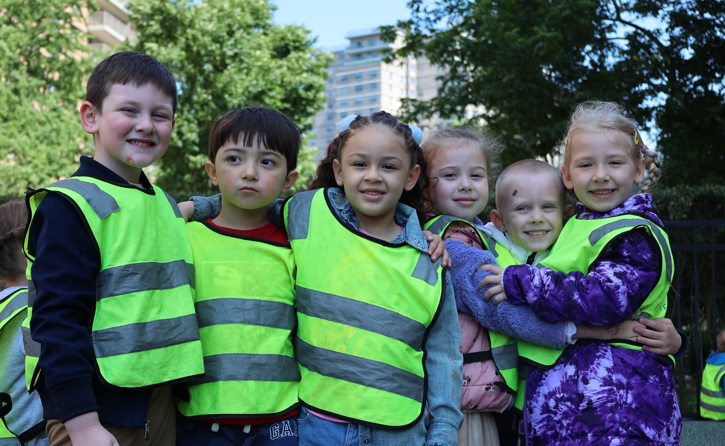 Group of children hugging and smiling during a spring outdoor educational activity