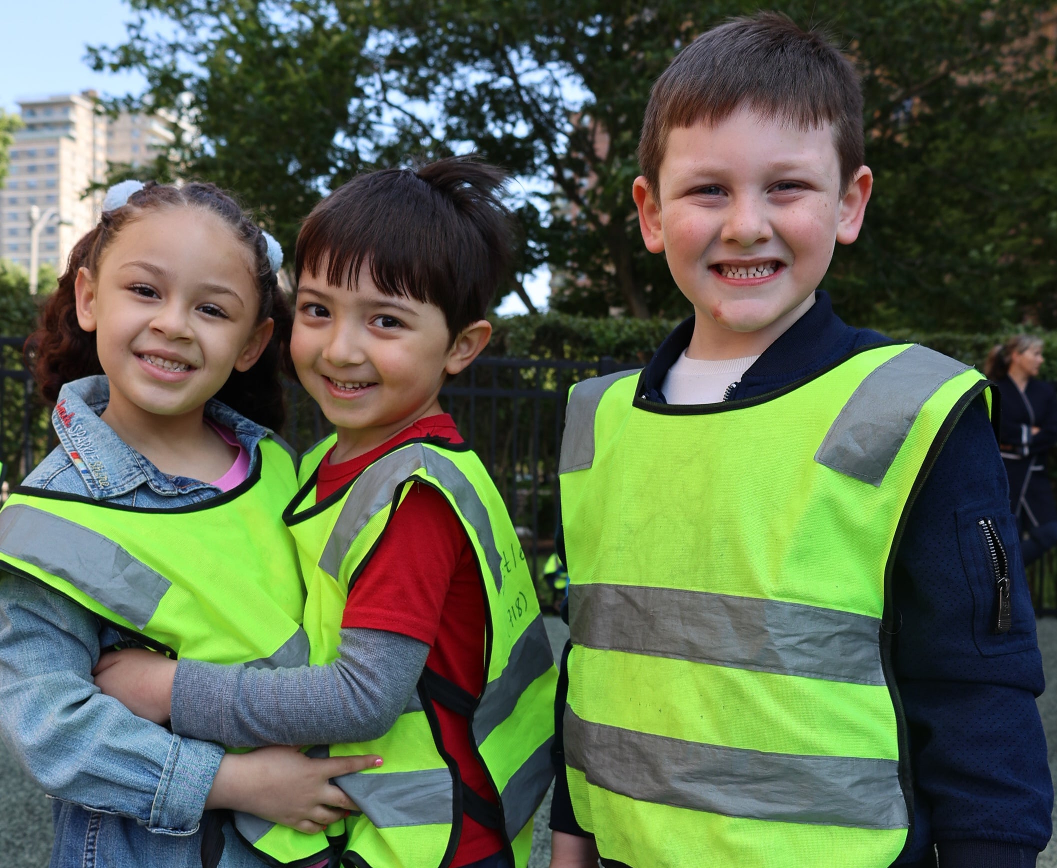 Three happy children hugging during a spring camp activity at Little Scholars Daycare