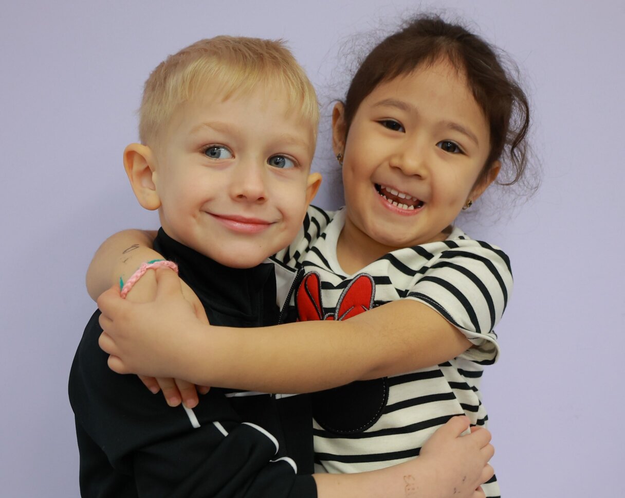  Smiling boy and girl hugging each other at Little Scholars Daycare
